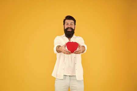 Love you. Being honest. Romantic guy with red heart toy. Romance concept. Celebrate valentines day. Romantic hipster sharing love. Spread love around. Generous lover. Love symbol. From sincere heartの写真素材