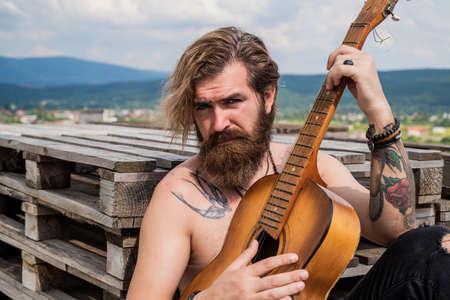 Let the music take you away. brutal handsome man with moustache play guitar. mature musician and singer. casual styled guitarist. modern looking bearded hipster with acoustic guitarの写真素材