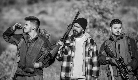 Hunters with rifles in nature environment. Illegal hunting. Hunters brutal poachers. Poacher partner in crime. Poaching concept. Activity for brutal men. Hunters poachers looking for victimの写真素材