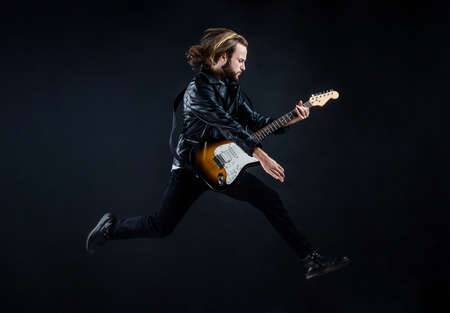 musician guitar player jumping. playing rock music. stylish crazy man. string musical instrument.の写真素材