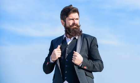 Facial hair beard and mustache care. Beard fashion trend. Start with grooming routine and ultimately lead better world. Man bearded hipster wear formal suit blue sky background. Vintage style beardの写真素材
