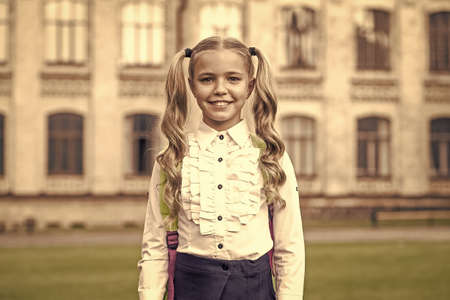 Be smart. Happy girl outdoors. Child girl back to school. Little girl wear school uniform. Primary school girl with long hair. Study and education. Childhood and girlhood, vintage filterの写真素材