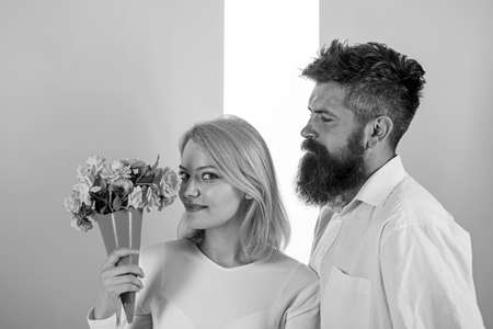 Woman enjoy fragrance bouquet flowers. Couple in love happy celebrate anniversary. Man with beard...