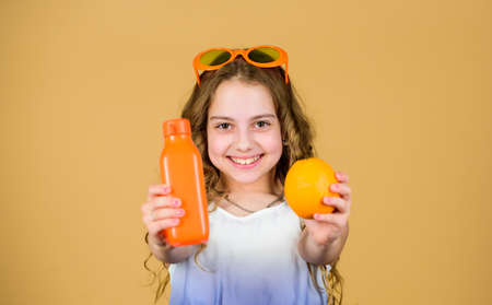 Health care. Summer vitamin diet. Natural vitamin source. happy girl drink fresh orange juice. little girl in fashion glasses. Vitamin nutrition. refreshing vitamin juice. This is my favorite foodの写真素材