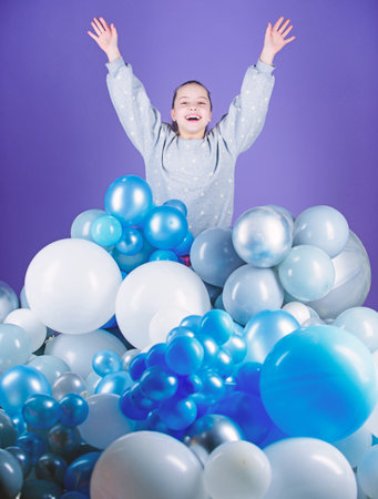 Obsessed with air balloons. Having fun. Balloons theme party. Girl between air balloons. Birthday party. Childrens day. Carefree childhood. All those balloons for me. Happiness positive emotionsの写真素材