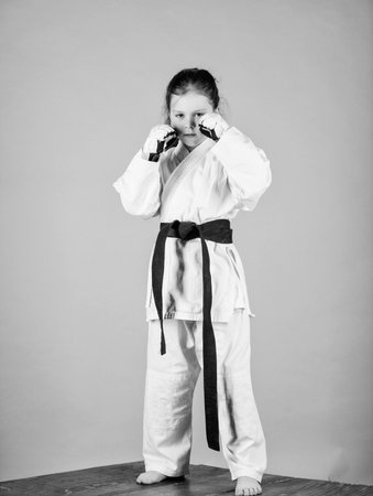 knockout. energy and activity for kids. little girl in gi sportswear. small girl in martial arts uniform. practicing Kung Fu. happy childhood. sport success in single combat. Stretching away stressの写真素材