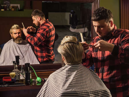 Guy with long dyed blond hair close up rear view. Consider yourself warned. Hipster client getting haircut. Barber scissors. Cut hair. Barber making hairstyle for bearded man barbershop backgroundの写真素材