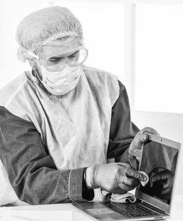 corona virus concept. stay safe at home. coronavirus pandemic outbreak. hygiene on lock down. remote work concept. man in doctor uniform. man wear respirator mask, gloves and protective glassesの写真素材