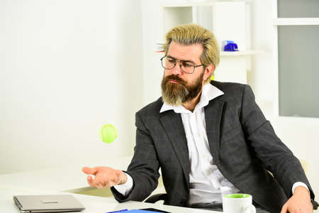 male employee playing tennis in the office. successful business startup. man play tennis ball in workplace. Win a victory. office entertainment. leisure activity. team building and teamworkの写真素材