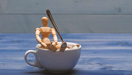 Vitamin cocktail. Health problem. Immunity care and medicine vitamins. Mixing medicines. Fast treatment. Take medicine concept. Medicines dose. Wooden human dummy near cup full pills and tabletsの写真素材