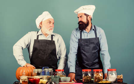 Homemade meal. Father and son culinary hobby. Family restaurant. Mature bearded men professional...