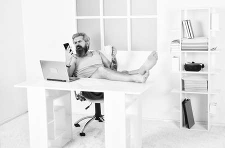 Lockdown self isolation and quarantine. Barefoot guy working from home. Man work laptop. Too lazy to work. Comfortable workplace. Social networks. Social distancing. Always wanted to work from homeの写真素材