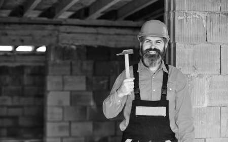 professional repairman use hammer. build and construction. Skilled architect repair and fix. engineer career. mature bearded man in hard hat. man builder in an unfinished buildingの写真素材