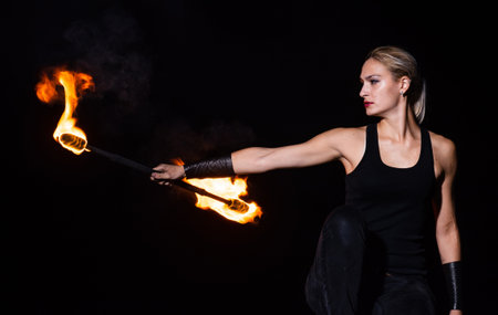 Amusement and entertainment. Sensual girl twirl burning baton in darkness. Baton twirling.の写真素材