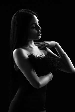 Seductive lady. Beautiful decollete. Fashion concept. Fancy clothes. Fashion shop. Emphasize sexuality. Sexual hint. Attractive woman fashion model. Fashionable girl wearing dress with feathersの写真素材