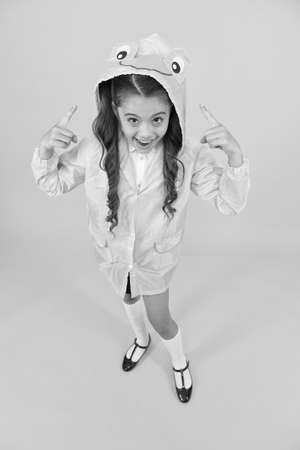 Rainproof accessories make rainy fall day pleasant. Waterproof accessory. Kid girl happy wear raincoat. Cute raincoat kids would love. Frog style. Schoolgirl hooded raincoat enjoy fall weatherの写真素材