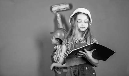 Control renovation process. Sisters happy renovating home. Home improvement activity. Kids girls planning renovation. Repaint walls. Move in new apartment. Children sisters run renovation their roomの写真素材