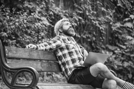 Doing research. successful entrepreneur. mature man sitting on park bench with laptop and checking email. Freelancer man working on computer. Businessman using notebook in park. Escaped of officeの写真素材