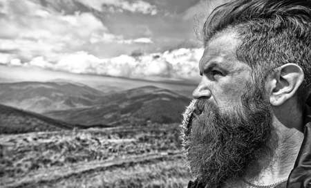 man hipster traveler with beard and moustache portrait on mountainの写真素材