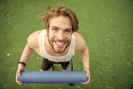 happy man with muscular body holding yoga or fitness matの写真素材