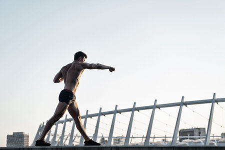 Man doing boxing exercises on roofの写真素材