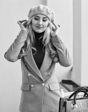 Young girl outdoor in autumn. Fashion brunette model in nice clothes. Wearing jacket and hold handbag. Style blond girl in fall jacket. girl wearing stylish clothes posing outsideの写真素材