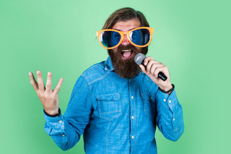 speak louder. male speaker with mic. vocal. happy smiling mature man. guy with beard sing in...