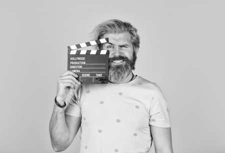 Watch movie. Film director. Actor casting. Shooting scene. Favorite series. Action. Cinema production. Creative producer. Bearded man hold movie clapper. Film making concept. Clapperboard copy spaceの写真素材