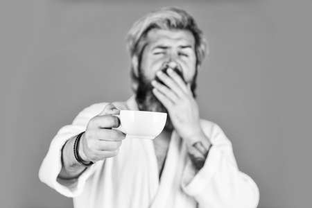 Here is your morning coffee. hipster start day. early awakening with cup of espresso. good morning coffee. need some energy charge. drink fresh coffee beverage. bearded man in bathrobe with cupの写真素材