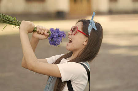 Birthday party. Happy girl have fun with flowers. Party look of small child. Holiday party. Enjoying celebration. Summer holidays. Inspired events. Party starの写真素材