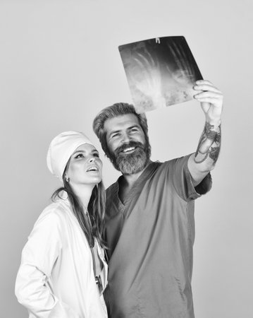 Diagnostics bone damage. Radiographs tomography result. Doctor and nurse. Doctor discussing x ray snap with colleague. Modern diagnostics abilities. Professional diagnostics. Medical consultationの写真素材