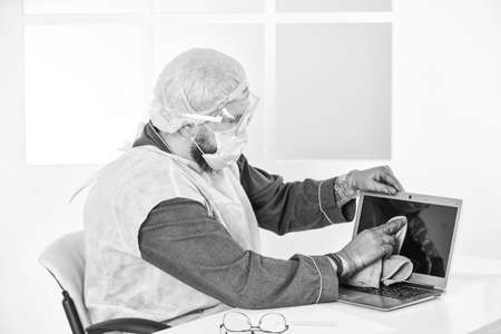 man wear respirator mask, gloves and protective glasses. stay at home. pandemic outbreak. hygiene on lock down. remote work concept. man in sanitary doctor uniformの写真素材
