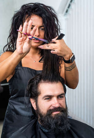 mature hipster with beard and moustache care his hair in barbershop, barberの写真素材