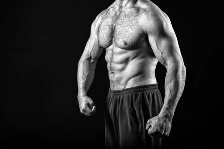 Muscle concept. Muscle torso with six pack abs of man, black and white. strong man isolated on black.の写真素材