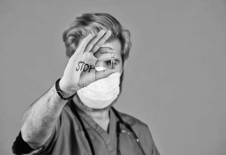 Man in medical lab. Protective mask. Stop epidemic. Virus concept. Danger zone. Epidemic infection. Open palm stop gesture. Critical number or density of susceptible hosts. Epidemic thresholdの写真素材
