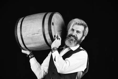 degustator man. Sommelier tastes expensive drink. Elegant waiter carry wine. working in wine cellar. bar or winery. wine degustation. Bearded businessman in elegant suit with wine barrelの写真素材