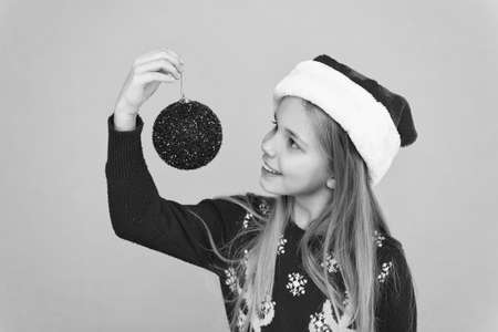 Winter shopping. Decorative accessories. Decorating christmas tree. Girl smiling face hold ball. Let kid decorate christmas tree. Festive mood. Add more decorations. Getting child involved decoratingの写真素材
