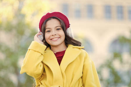 school fall season. small girl listen audio book. small girl in headset. online education. music lover. ebook technology. cheerful parisian girl in french beret. autumn fashion. Your guide to answersの写真素材