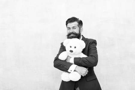 His favorite toy friend. Happy businessman hug teddy bear blue background. Bearded man smile with toy friend. Friend and friendship. Adoption and adoptive parent. Perfect lovable friend, copy spaceの写真素材