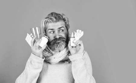 Apothecary concept. Lot of medicines. Man sick leave at home. Bottle blister plastic container. Medicines effective treatment. Bearded guy messy hair hold pills tablets vitamins medicines in handsの写真素材