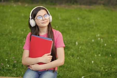 Girl listening summer melody wireless headphones nature background, hobby and leisure concept