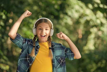 Exclusive holidays for winner. Happy child make winner gesture. Small winner celebrate to music natural outdoors. Celebrating winning. Casual fashion. Trendy style. Summer vacationの写真素材