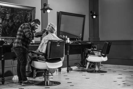 Perfect style. Portrait of stylish man beard. shaving. Hairstylist in barbershop. man in hair salon with hipster haircut. beard and mustaches. Professional hairstylist in barbershop interiorの写真素材