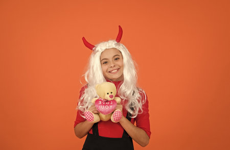 happy witch kid with teddy bear toy wear costume horns of imp on halloween party, halloween presentの写真素材