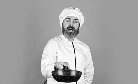 Cooking like pro. Regular cooking. Easy tasty meal prepared at home. Homemade breakfast. Preparing food in kitchen. Cooking food concept. High quality frying pan. Bearded man cook white uniformの写真素材