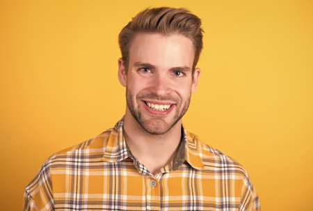 Happy unshaven young guy smile with healthy teeth yellow background, dentalの写真素材