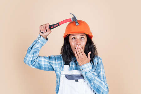 Support for your home. repairing tools used in engineering. architect working with hammer. female foreman on construction site. carpenter assistant wear protective helmet. girl in workshop uniformの写真素材