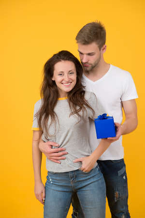 Pack your present in box. Happy couple hold gift box. Wrapped present box with bow. Wrapping paper....