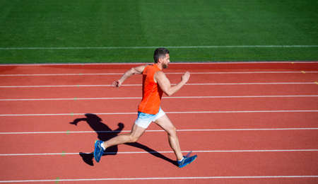 energetic athletic muscular man runner running on racetrack at outdoor stadium, challengeの写真素材