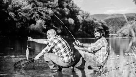 retired father and mature bearded son. big game fishing. relax on nature. fly fish hobby of men....